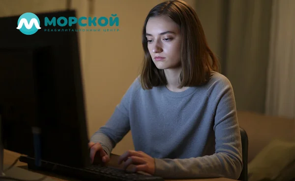 грустная девушка сидит за компьютером